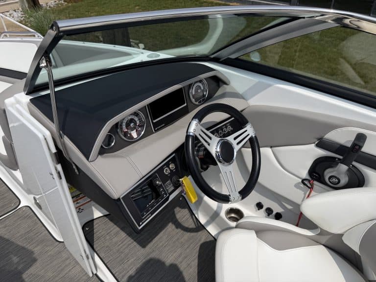Boat helm with steering wheel, gauges, and control panel at Hall's Sport Center.