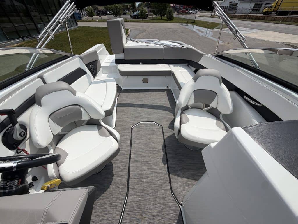 Boat interior with white cushioned seats and spacious layout at Hall's Sport Center. Perfect for boa.