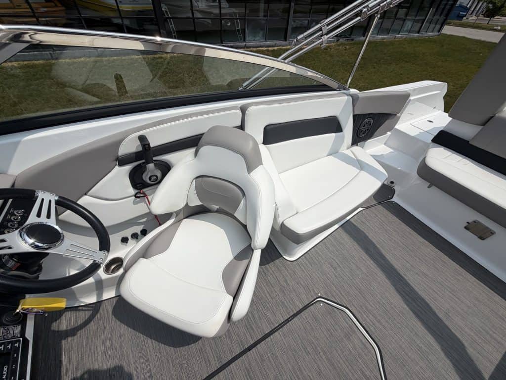 Luxury boat interior with white seating, modern controls, and sleek design at Hall's Sport Center.