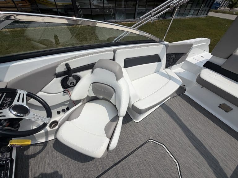 Luxury boat interior with white seating, modern controls, and sleek design at Hall's Sport Center.