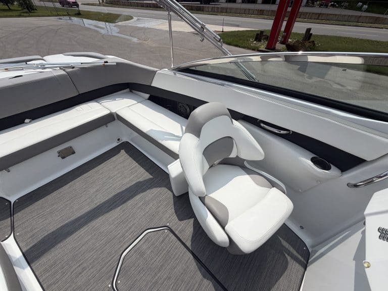 Boat seating and helm area with comfortable white cushioned seats and modern controls.