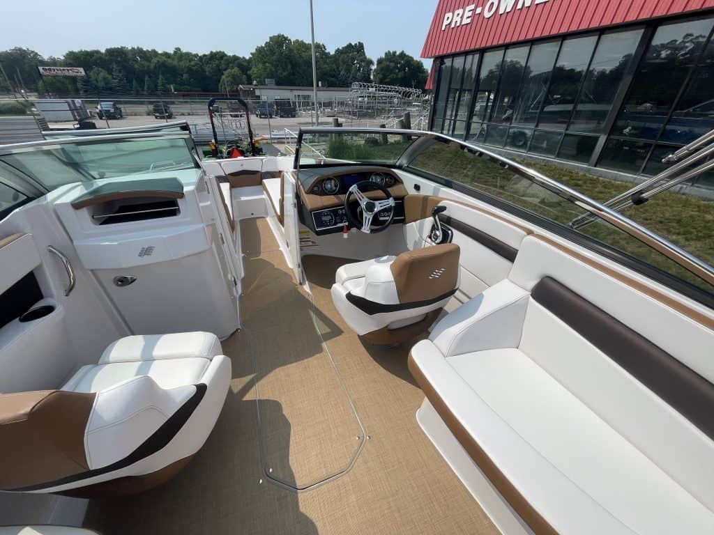 Luxury boat interior with white and brown seating and steering wheel.