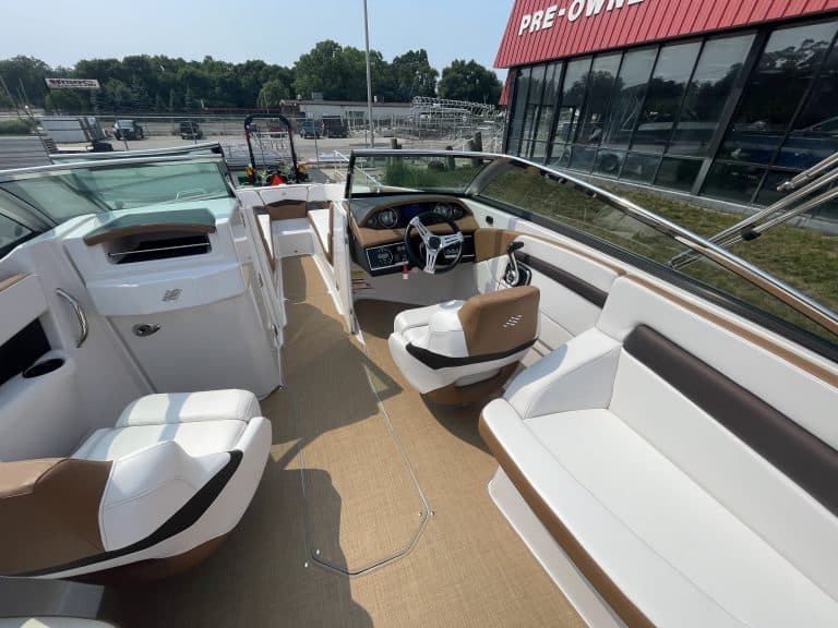 Luxury boat interior with white and brown seating and steering wheel.