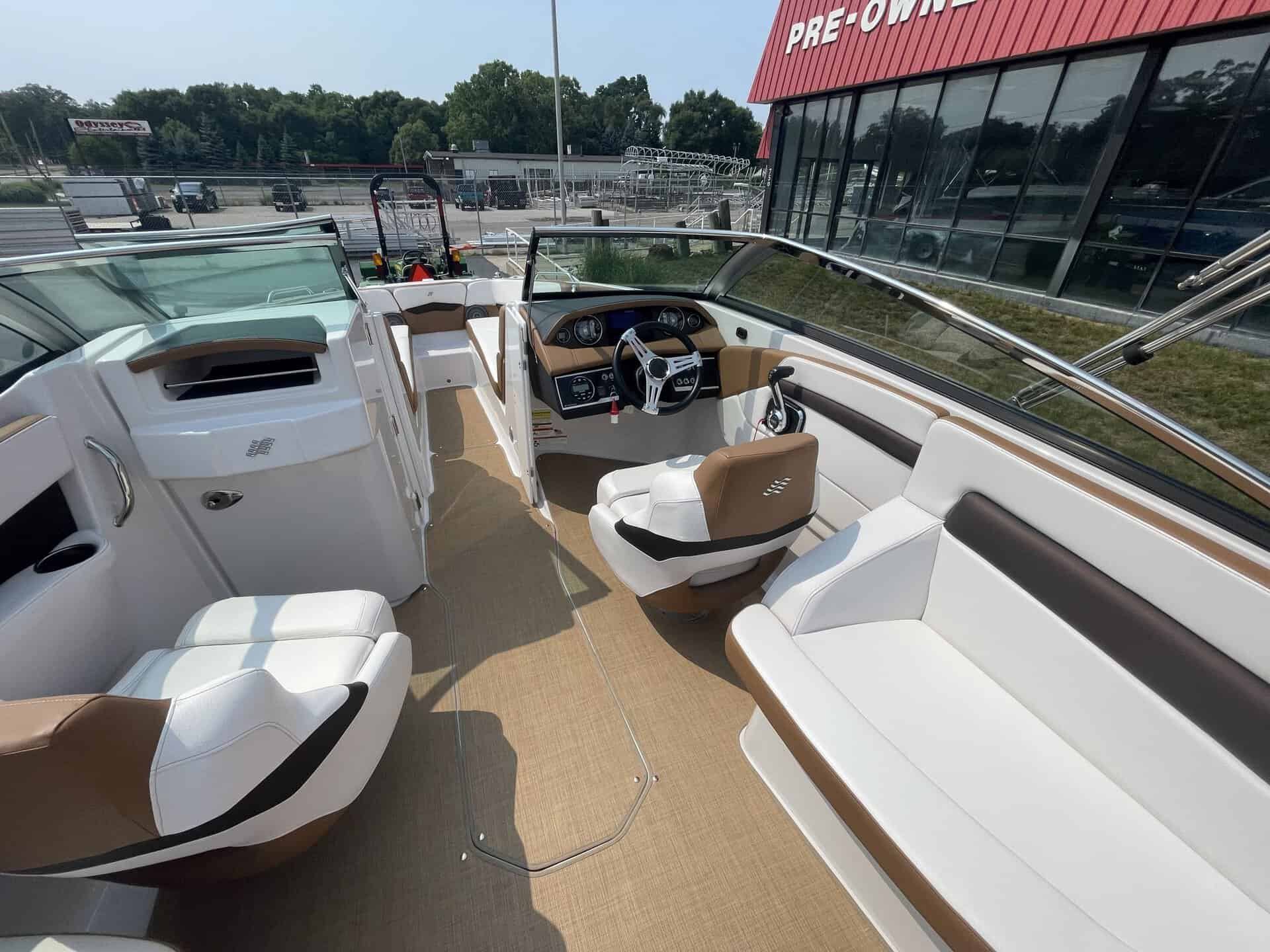 Luxury boat interior with white and brown seating and steering wheel.