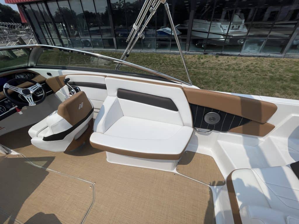 Luxury boat interior with white and brown seating and modern dashboard.