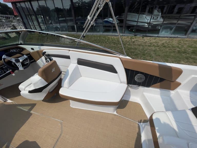 Luxury boat interior with white and brown seating and modern dashboard.