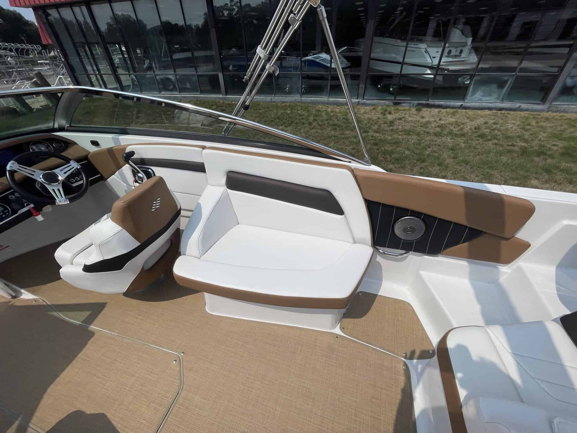 Luxury boat interior with white and brown seating and modern dashboard.
