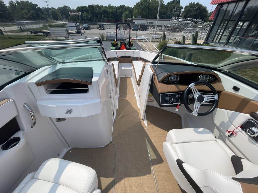Interior view of a 2018 Four Winns H260 boat with steering wheel and seating.