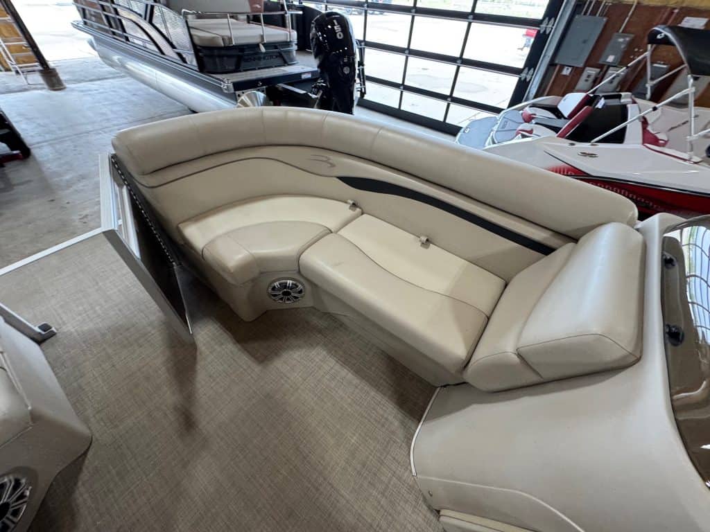 Pontoon boat with white upholstery and spacious seating.