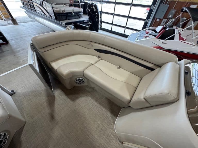 Pontoon boat with white upholstery and spacious seating.