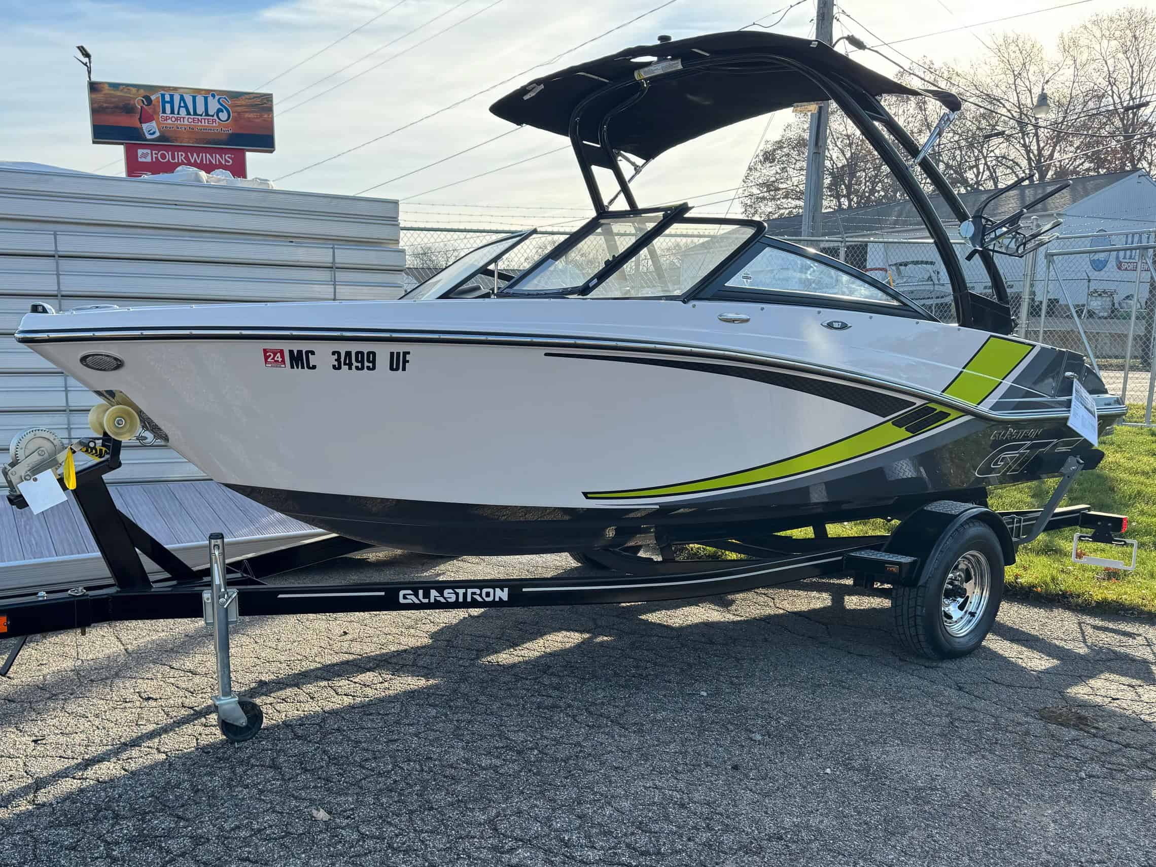 High-quality photo of a sleek, modern recreational boat on a trailer at Hall's Sport Center.