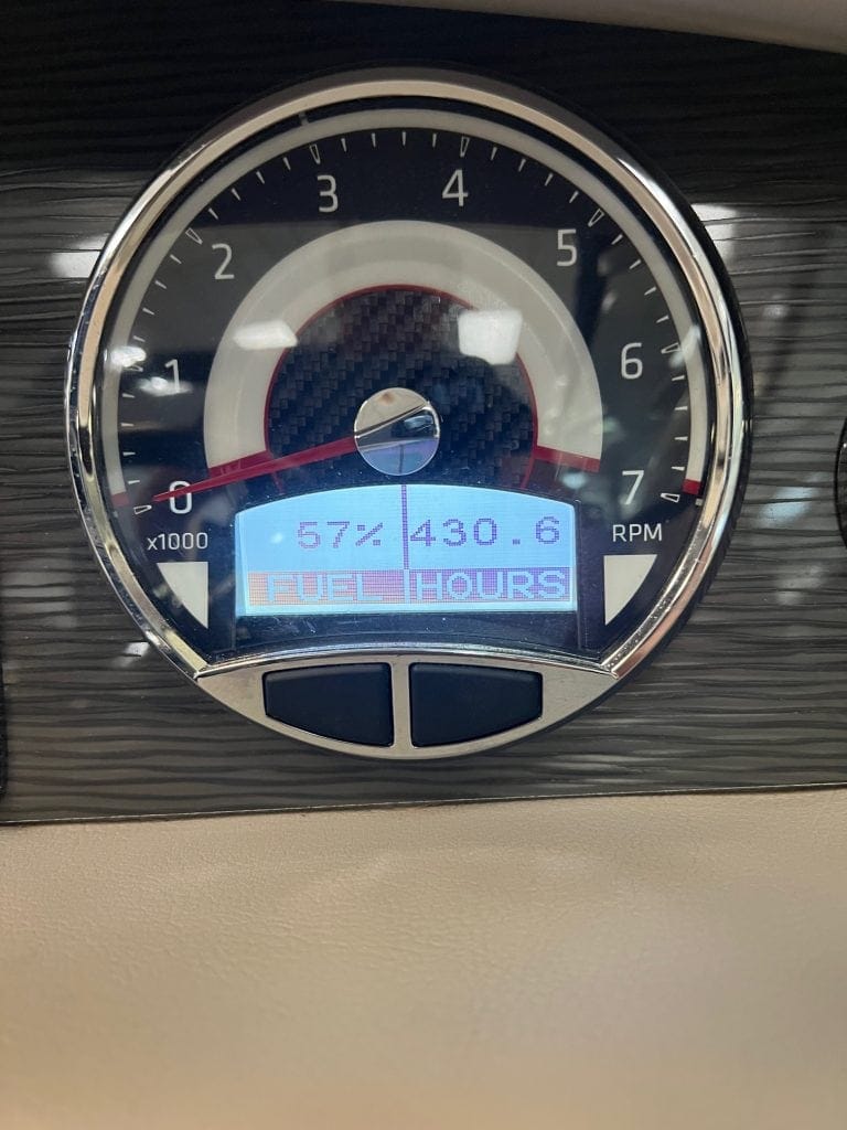 Dashboard display showing fuel level and engine hours.