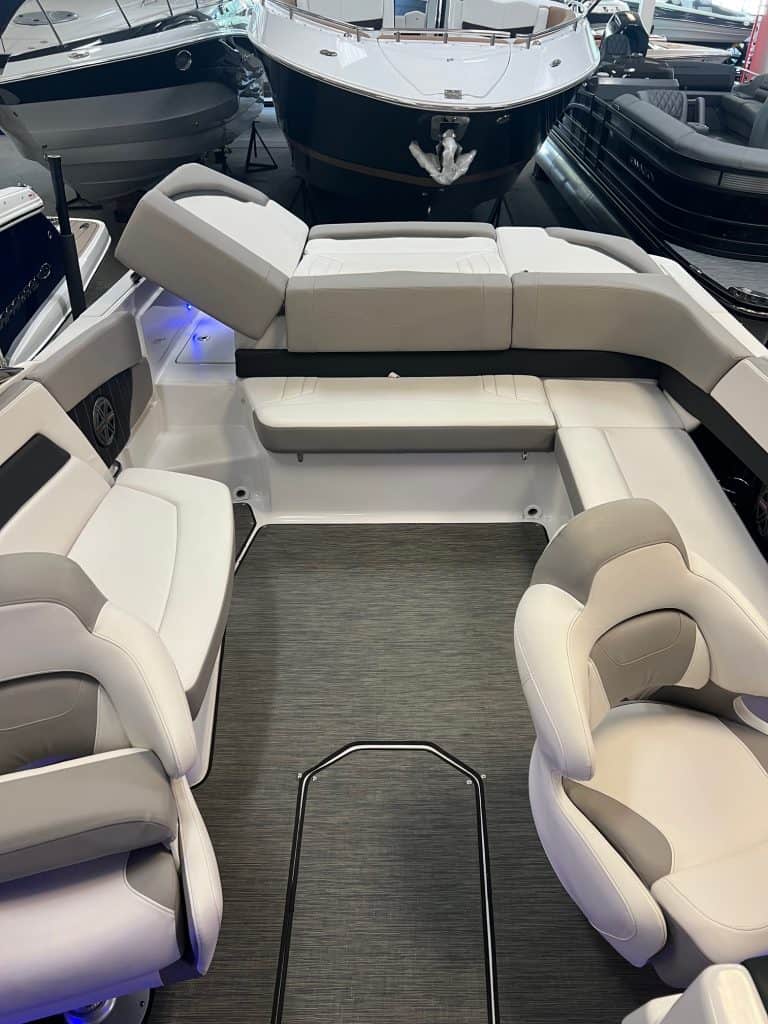 Comfortable white boat seating with multiple chairs and a sofa on a boat deck.