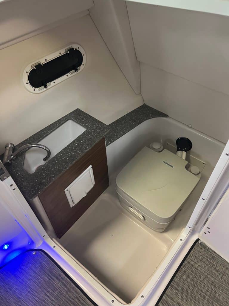 Compact boat bathroom with sink and toilet for marine comfort.