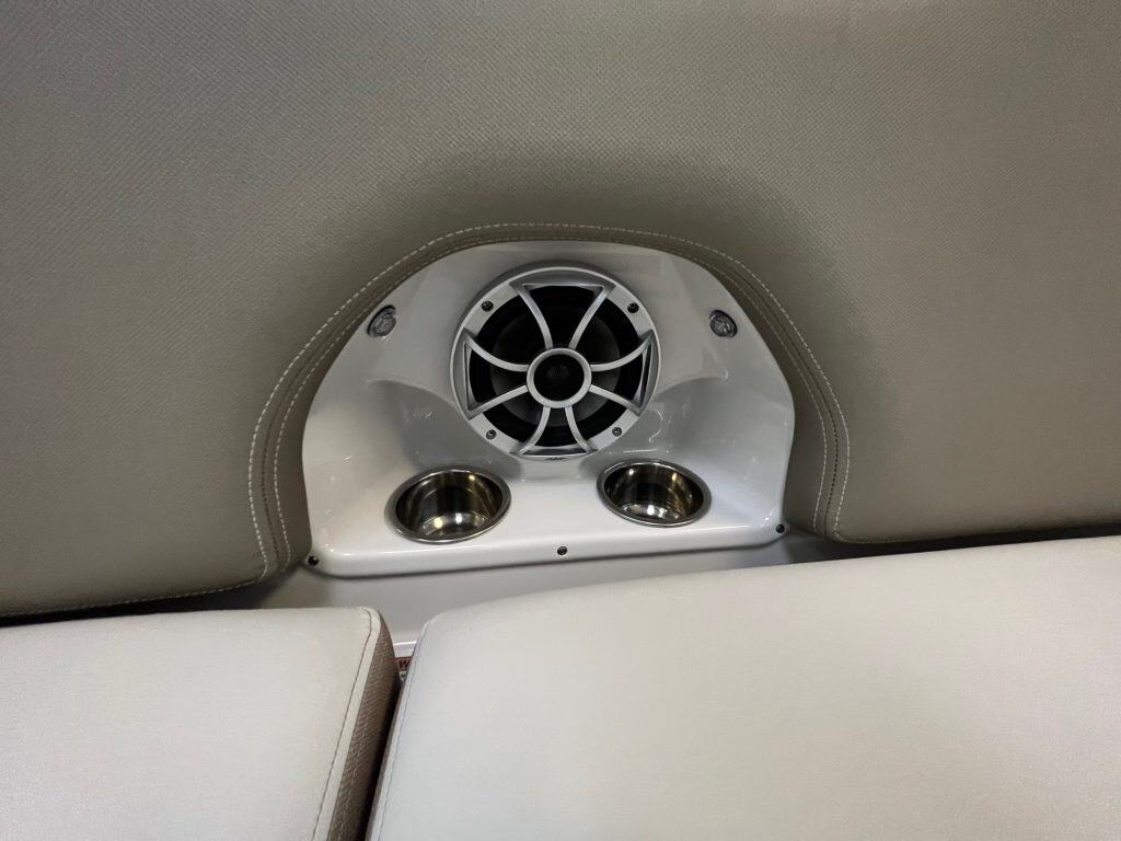 Stereo speaker and cup holders installed in a boat or vehicle seat area.