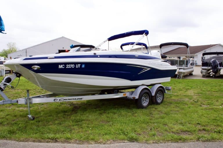Maritime recreational boat on a dual-axle trailer at the dealership lot.