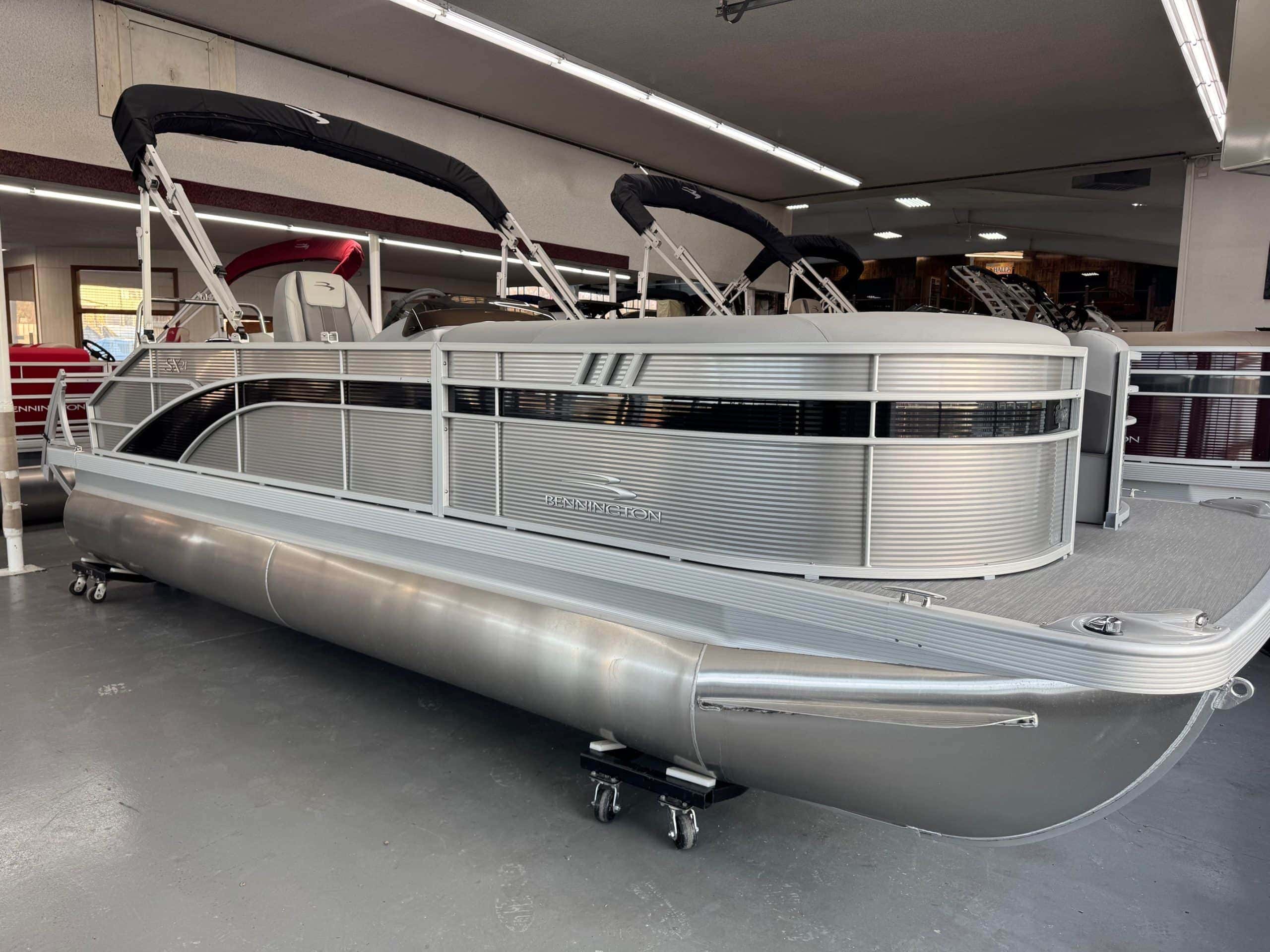 Modern aluminum pontoon boat displayed at Hall's Sport Center for sale.