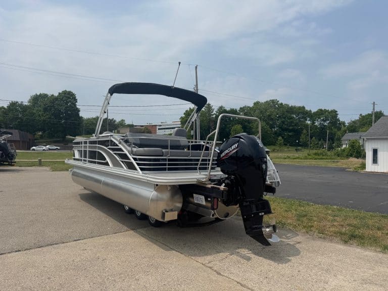 Pontoon boat with Mercury outboard motor on display at Hall's Sport Center. Perfect for leisure and watersports.