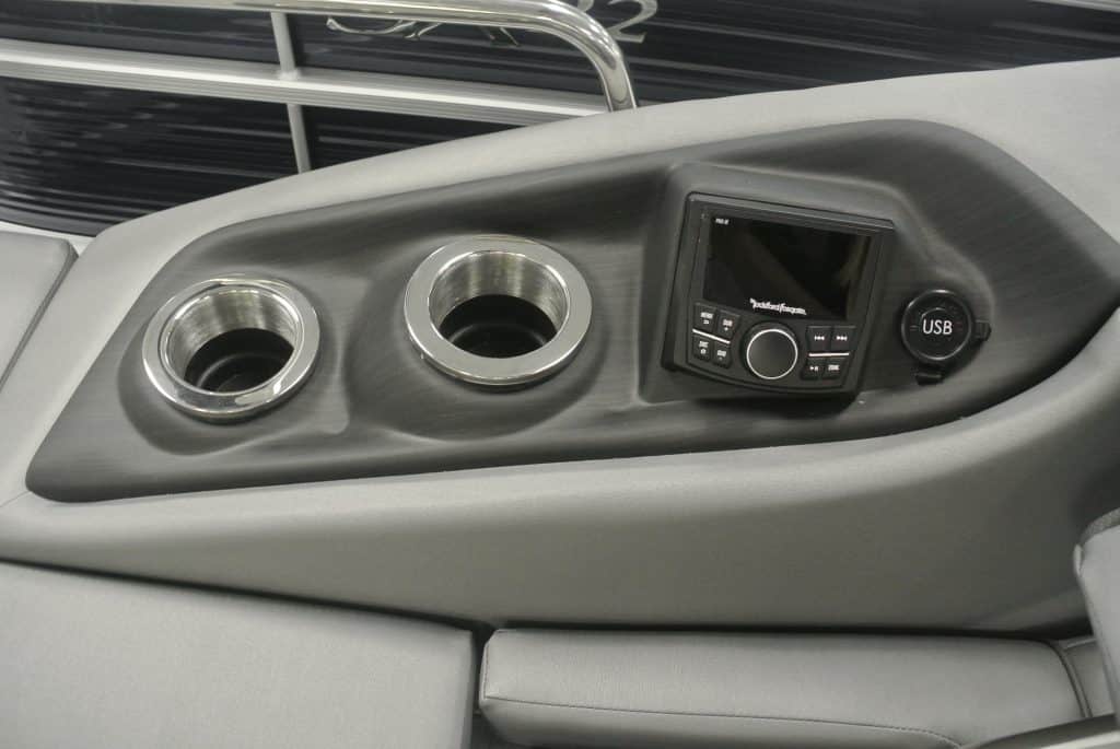 Boat console with cup holders, touchscreen radio, and USB port for boating enjoyment.