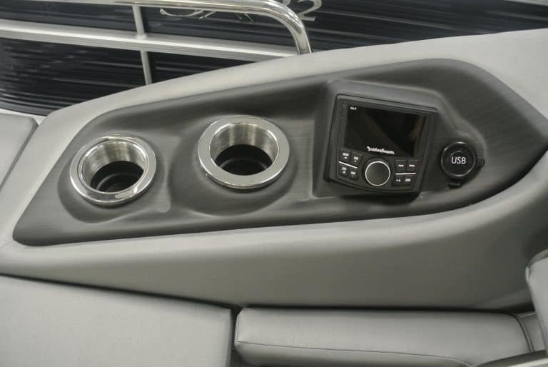 Boat console with cup holders, touchscreen radio, and USB port for boating enjoyment.