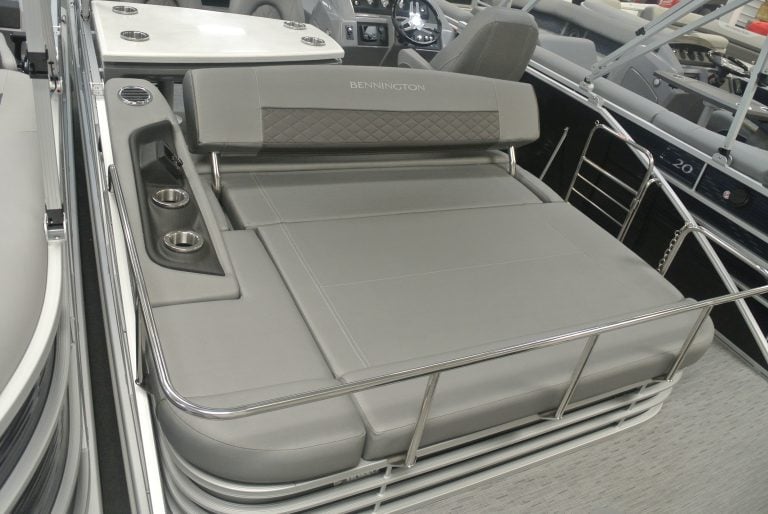 Comfortable boat lounge with gray upholstery and stainless steel railing at Hall's Sport Center.