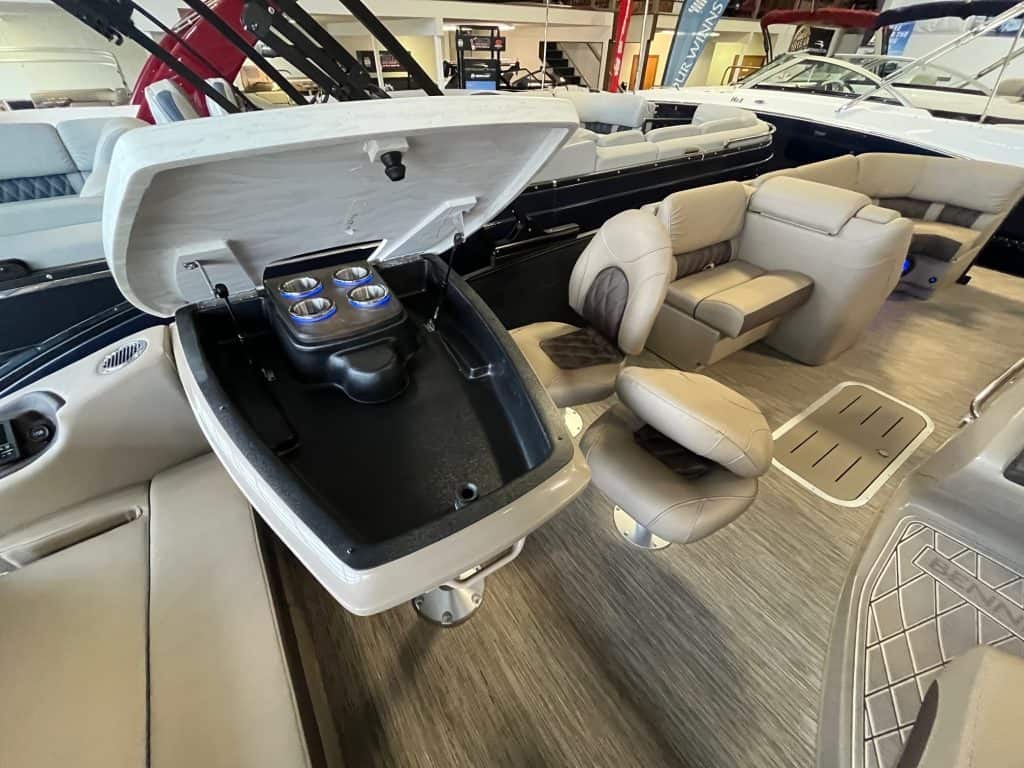 Pontoon boat interior with spacious, comfortable beige seating and built-in cupholders, perfect for boating fun.