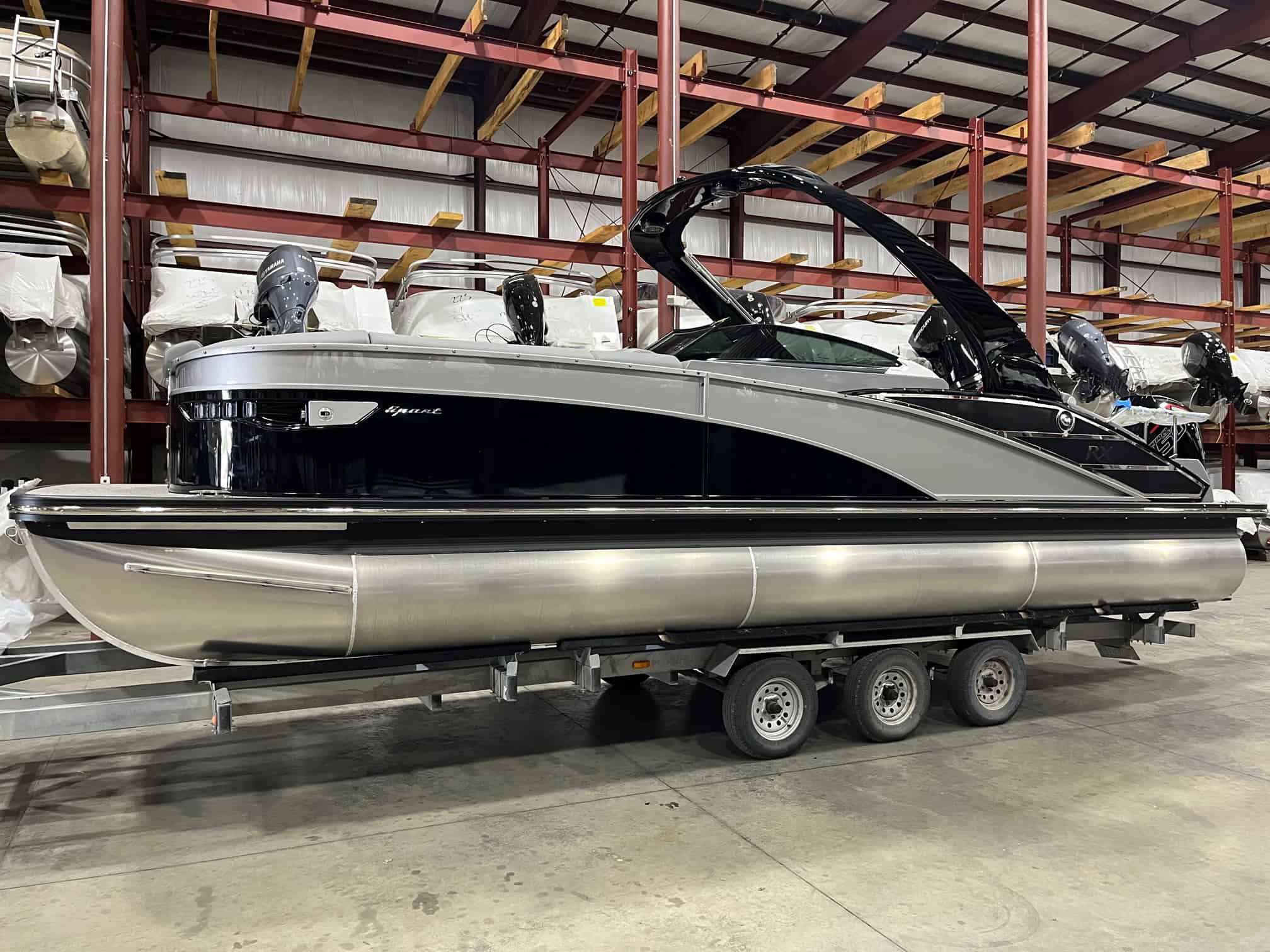 Modern black and silver pontoon boat with powerful motors, showcased at Hall's Sport Center for watercraft enthusiasts.