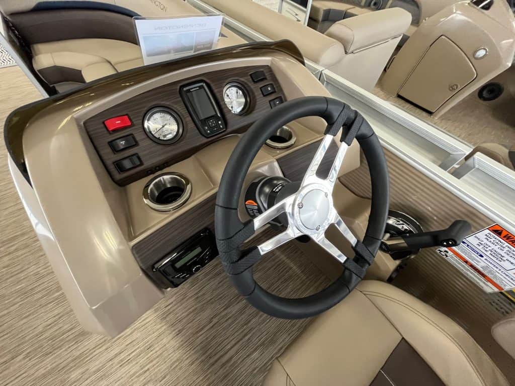 Boat steering wheel and dashboard with instrumentation and controls.