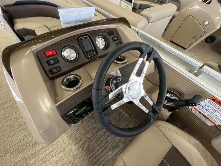 Boat steering wheel and dashboard with instrumentation and controls.