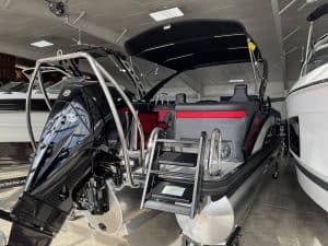 Bennington 24 MFB pontoon boat with outboard motor inside Hall's Sport Center showroom.