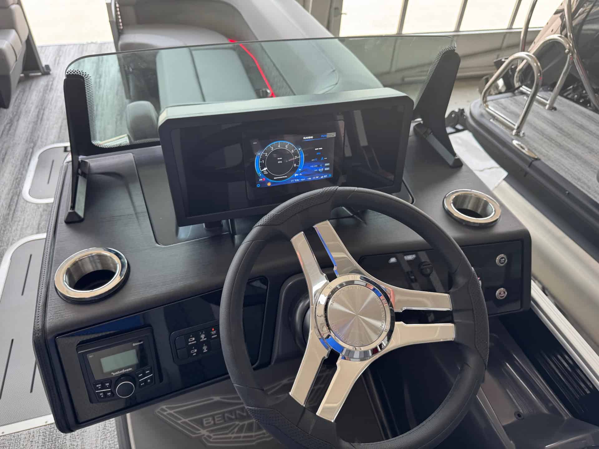 Bennington 24 MFB boat dashboard with digital display and steering wheel.