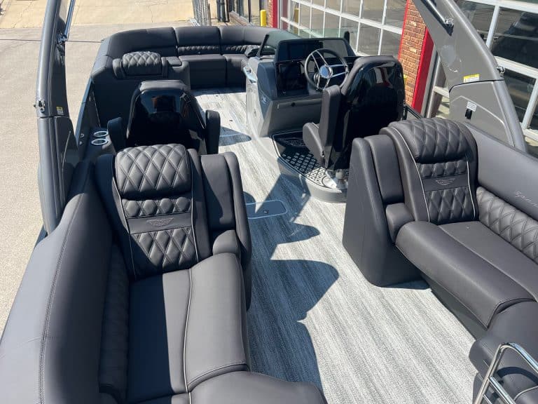 Modern Bennington 25 QFBA pontoon boat with luxurious seating and steering console.
