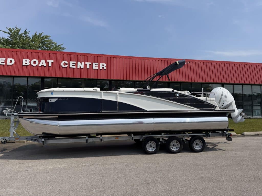 Boat on trailer outside Hall's Sport Center, showcasing watercraft for sale or rental.