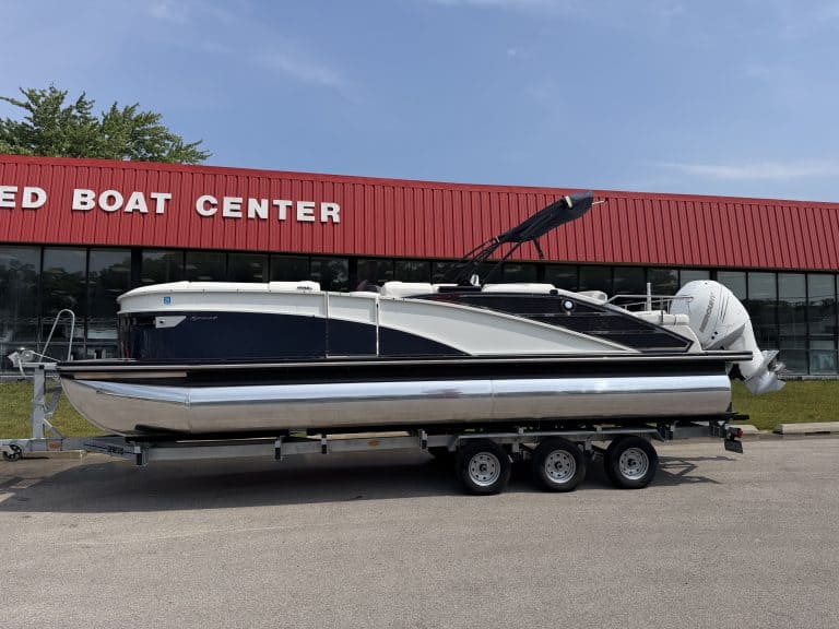 Boat on trailer outside Hall's Sport Center, showcasing watercraft for sale or rental.