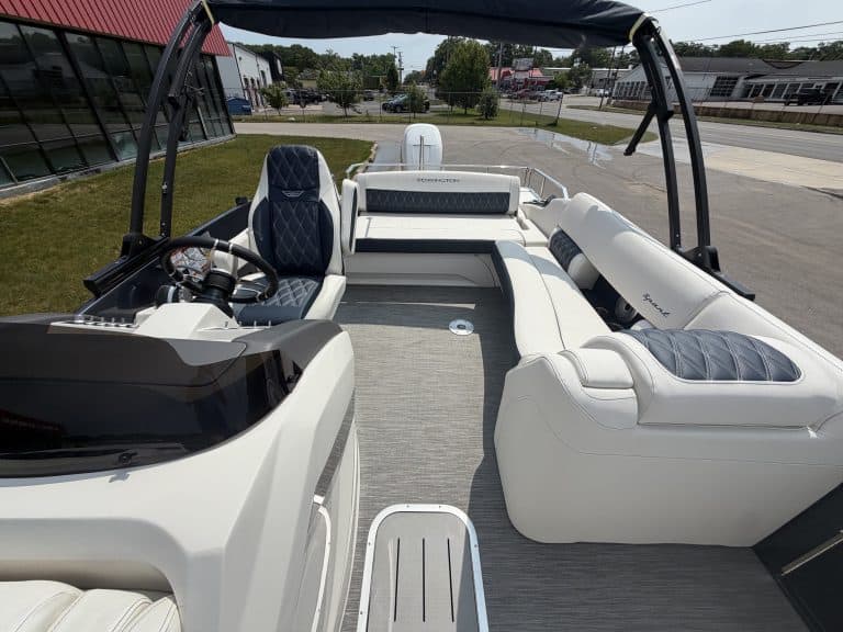 Boat with white and black seating at Hall's Sport Center, outdoor setting, sunny day.