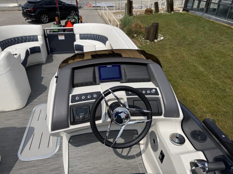 Helm station with steering wheel and navigation screen on a boat at Hall's Sport Center.