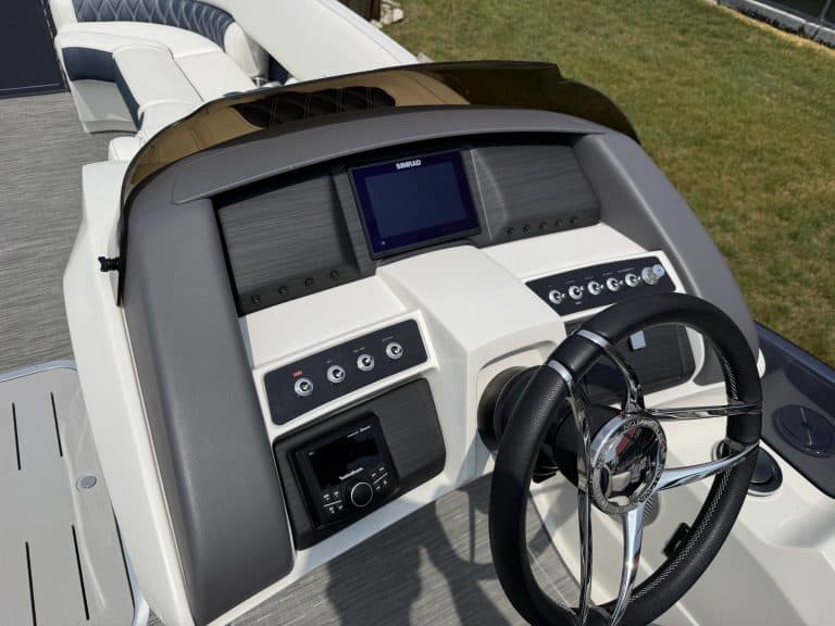 Boat helm with navigation screens and steering wheel, ideal for watercraft enthusiasts.