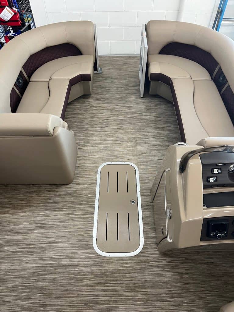 Seating area of the 2023 Bennington 23 LSR, featuring comfortable curved lounge seats for relaxing o.
