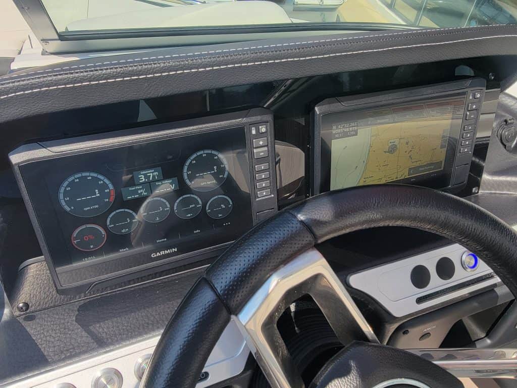 High-tech boat dashboard with Garmin navigation and digital gauges.