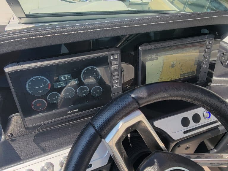 High-tech boat dashboard with Garmin navigation and digital gauges.