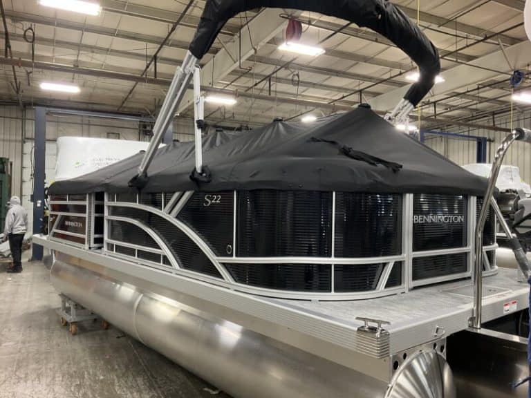 Pontoon boat with black canopy, aluminum hull, and spacious deck at Hall's Sport Center.