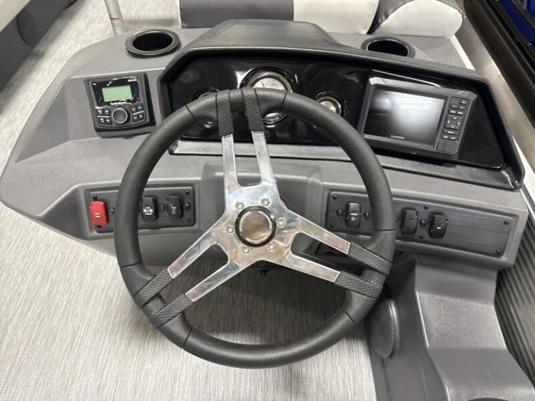 Dashboard of a Bennington 22 SSR boat with steering wheel and navigation equipment.