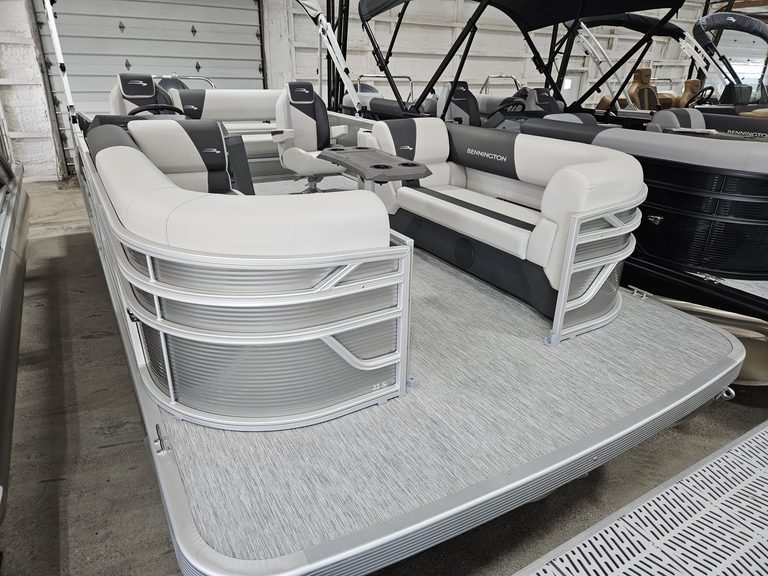 Luxury Bennington pontoon boat with white and black seating for leisure boating.