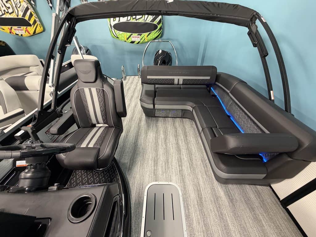 Interior view of a Bennington 22 MSB pontoon boat with seating and steering wheel.