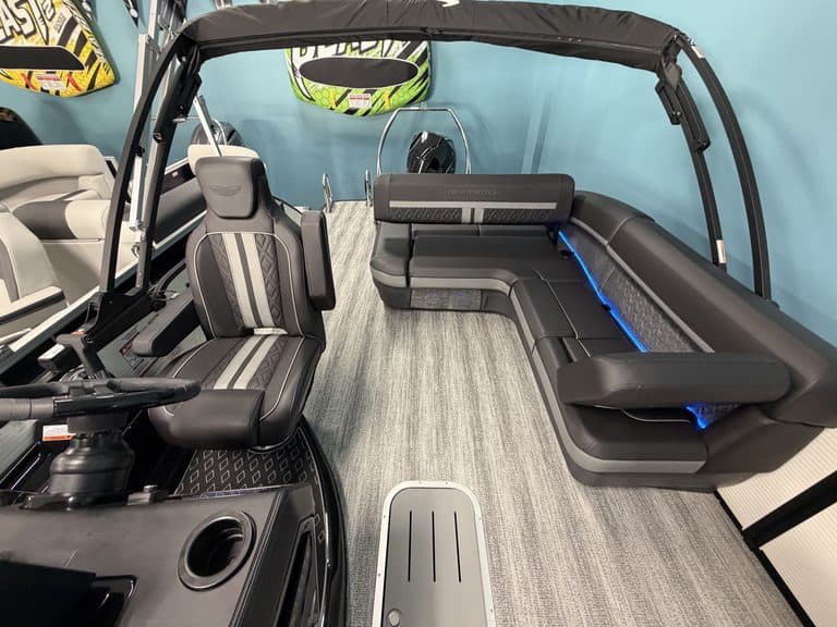 Interior view of a Bennington 22 MSB pontoon boat with seating and steering wheel.