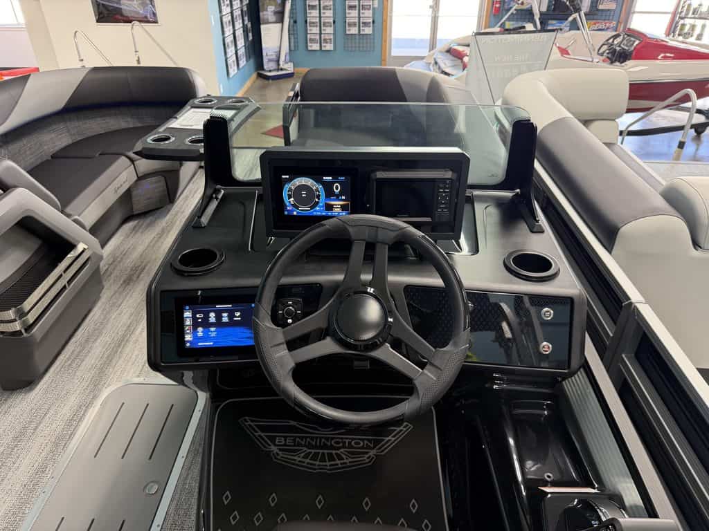 Boat dashboard with steering wheel and digital controls at Hall's Sport Center.