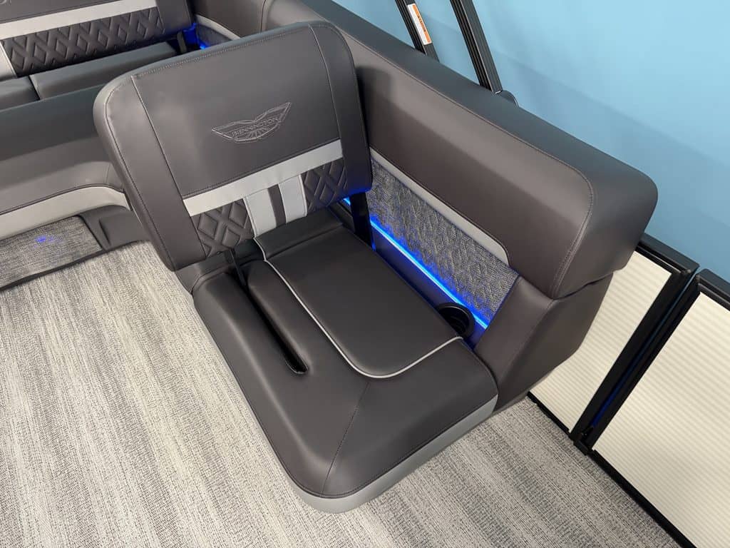 Comfortable airplane seat with side wall and blue LED lighting.