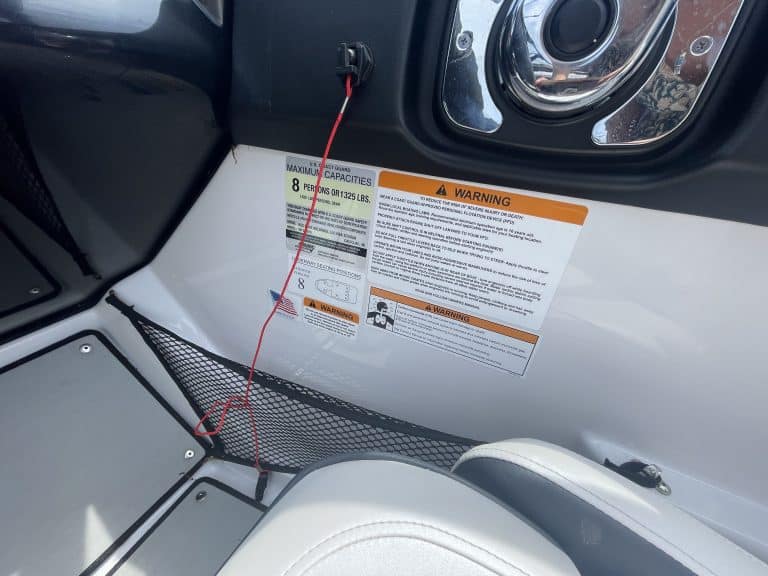 Close-up of boat interior with warning labels and speaker system.