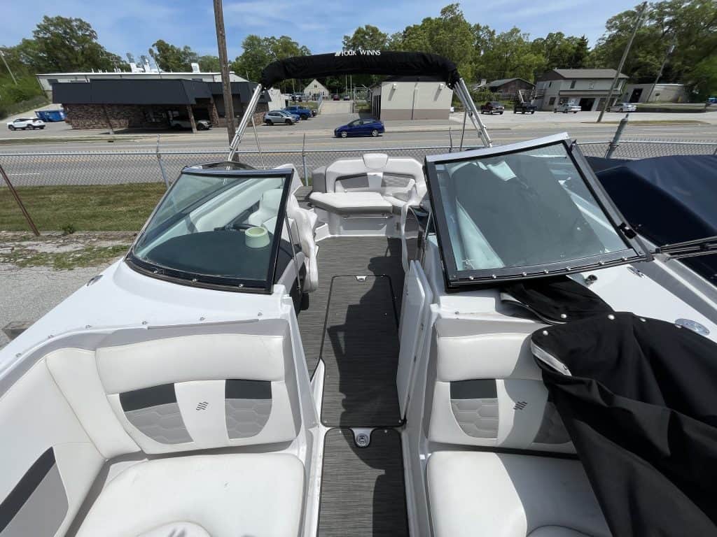 Luxury white boat with comfortable seating and canopy, ideal for water sports and leisure activities.