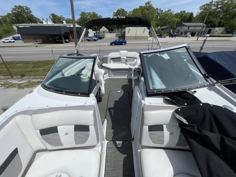 Luxury white boat with comfortable seating and canopy, ideal for water sports and leisure activities.